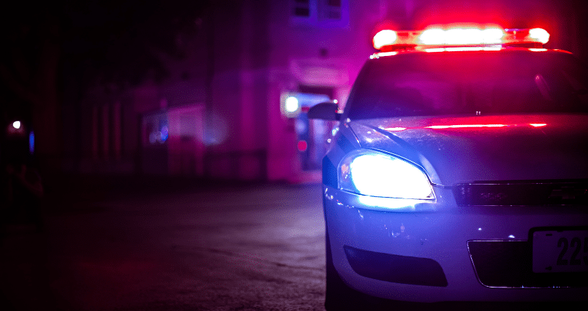police car at night next to building