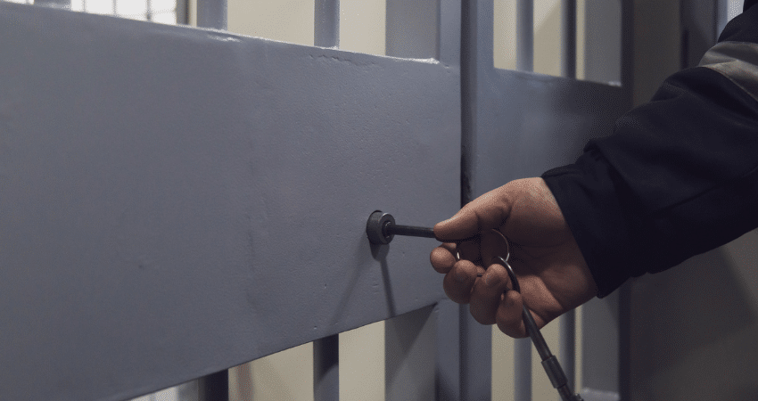 guard putting key in jail cell
