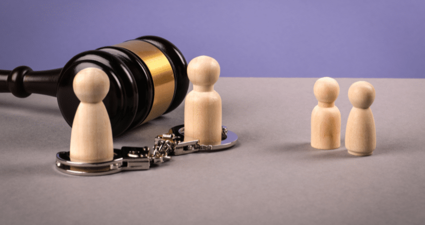 family wood figures with handcuffs and gavel