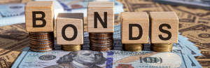 blocks that spell bonds on top of stacks of money and coins