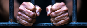 hands holding jail cell awaiting bail
